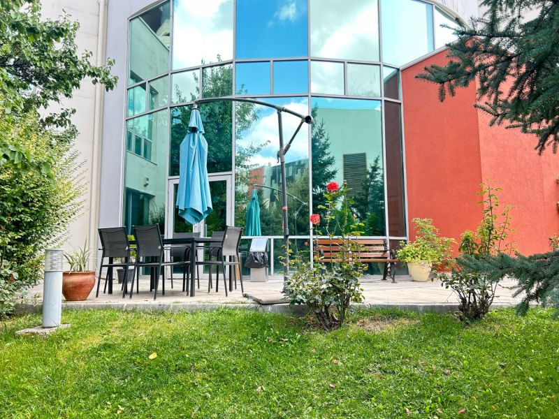 Cam cephe önünde şemsiyeli bahçe oturma terası